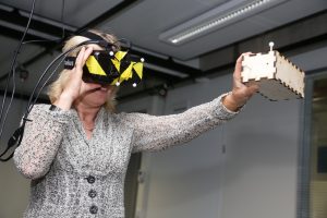 Jet Bussemaker, minister van OCW, was aanwezig bij de opening van het DesignLab. Hier maakt ze gebruik van een virtual reality-bril waarmee conceptontwerpen kunnen worden gevisualiseerd. Bron: Gijs van Ouwerkerk
