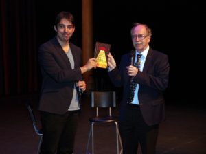 George van Hal overhandigt het eerste exemplaar van zijn boek Robots, aliens & popcorn aan Nobelprijswinnaar Gerard 't Hooft. 