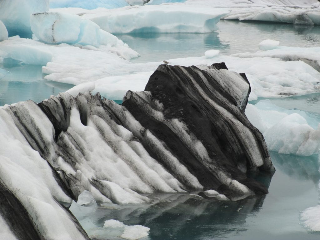 Kleurrijke ijsrotsen dobberen rond in een gletsjermeer, een schouwspel dat je in IJsland op een aantal plekken kunt aanschouwen.