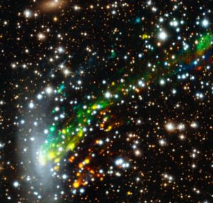 Het ontsnappende gas van sterrenstelsel ESO 137-001. Het gas dat verder weg beweegt ten opzichte van de aarde is rood gekleurd. Gas dat de aarde nadert, is blauw. Het plaatje is compleet gemaakt met opnamen van de Hubble-ruimtetelescoop. Bron: ESO/M. Fumagalli